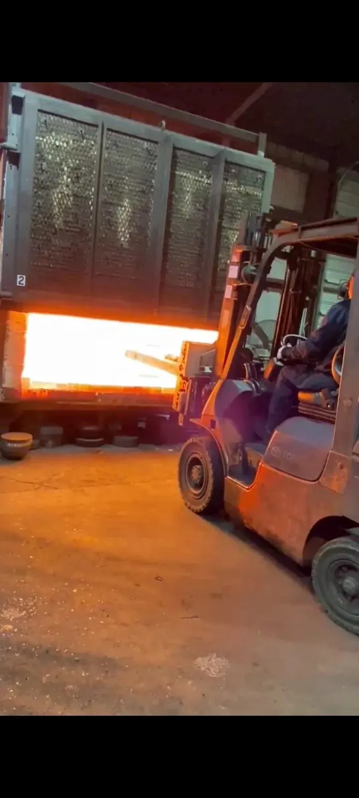 Forged steel components loaded into an in-house heat-treat furnace glowing at temperature