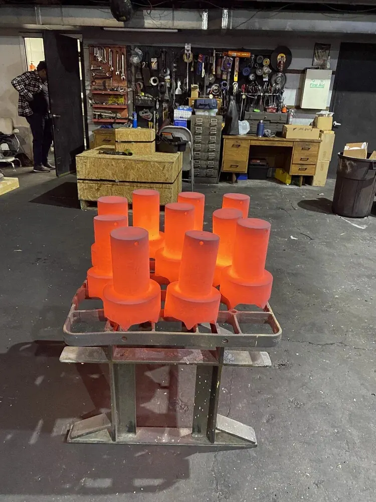 Heat-treated forged steel parts cooling on a rack after coming out of the MTS furnace